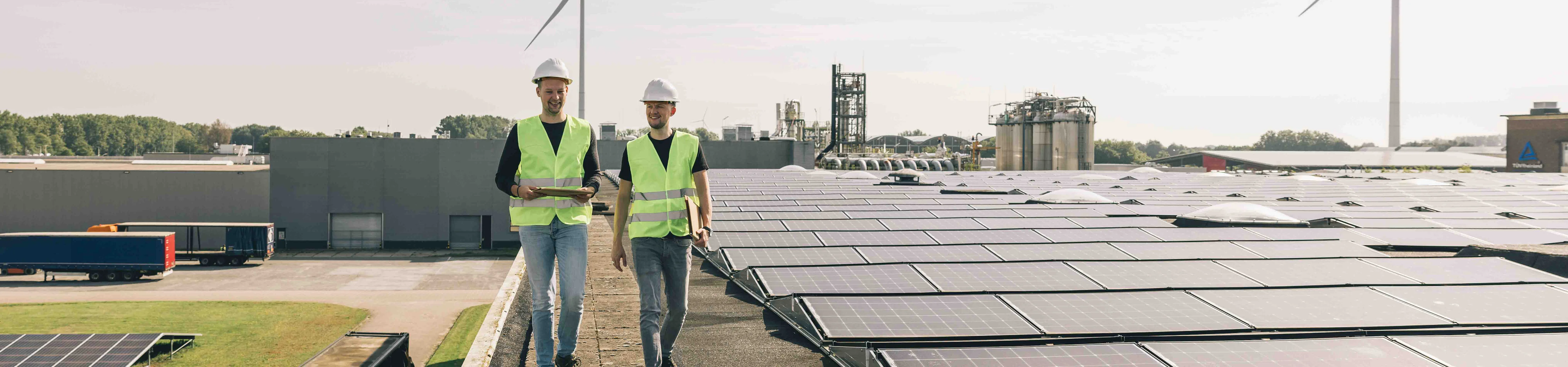 twee mannen lopend naast zonnepanelen