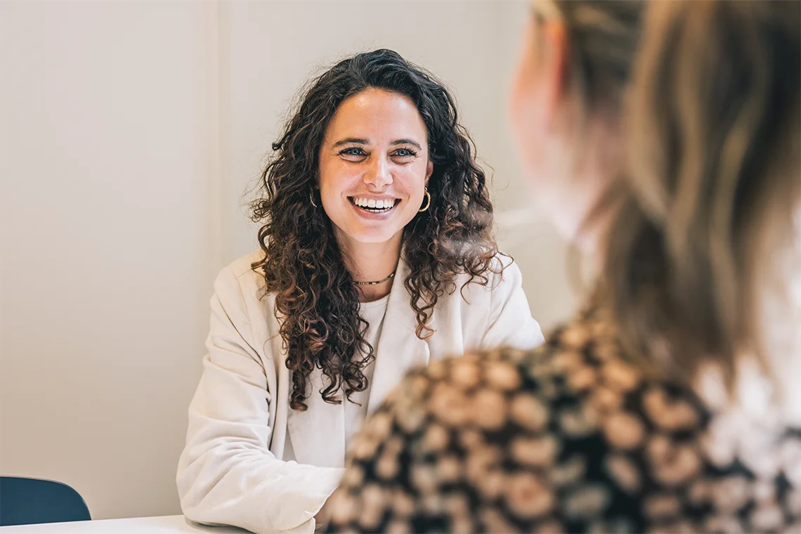 lachende vrouw in gesprek aan tafel